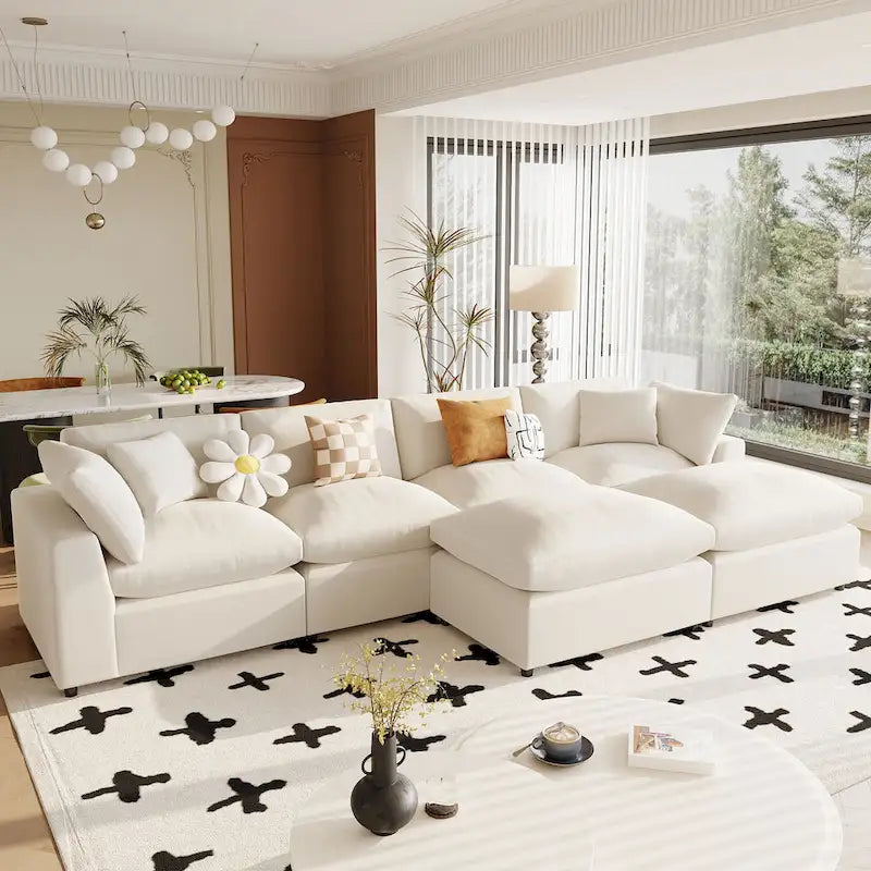 Un grand canapé d'angle moderne en U, doté de deux méridiennes spacieuses et d'un pouf amovible, parfait pour le salon.